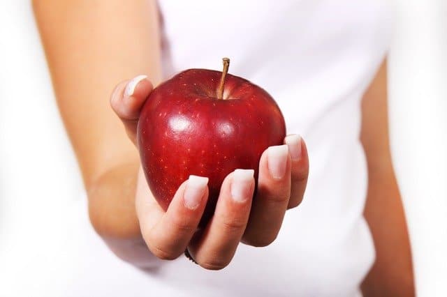 hand holding an apple-how to live a healthy lifestyle