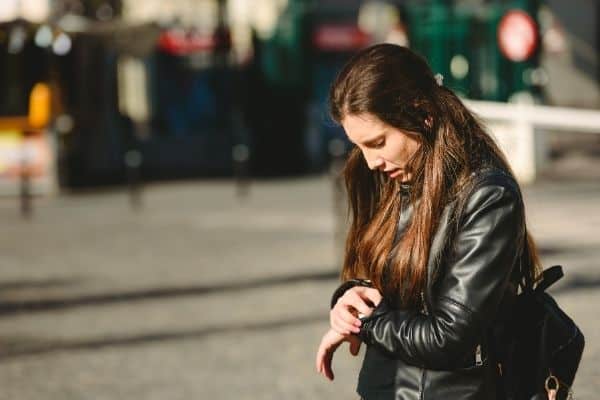 woman looking at her watch-how to get over someone fast blog post