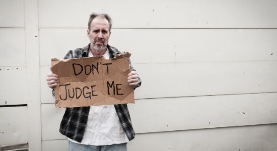 homeless man holding up a sign