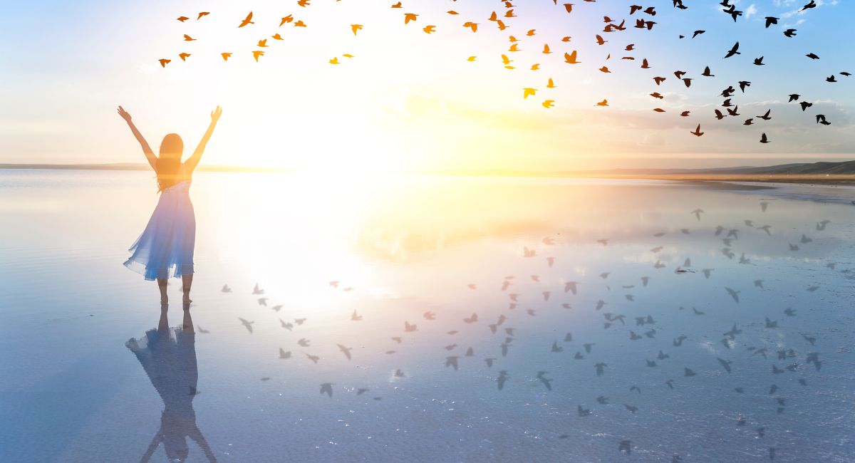 woman at beach with birds flying-freedom from emotional pain