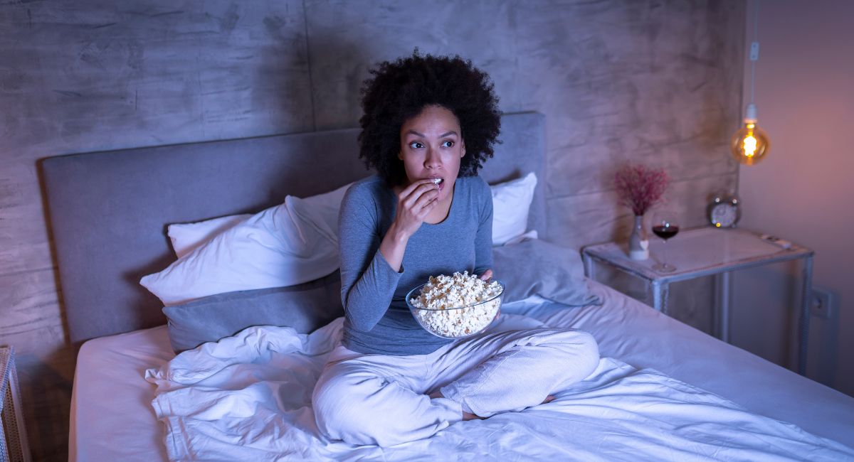 woman eating popcorn watching tv