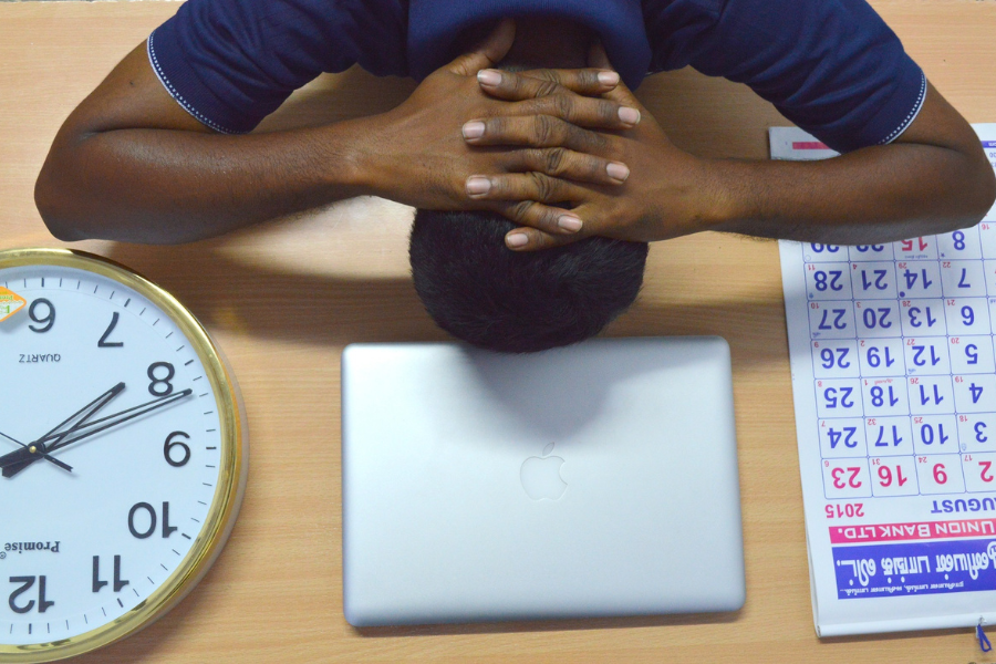 A stressed man with hands on his nape