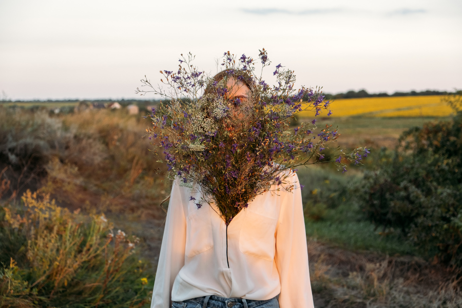 A woman with flowers covering her face