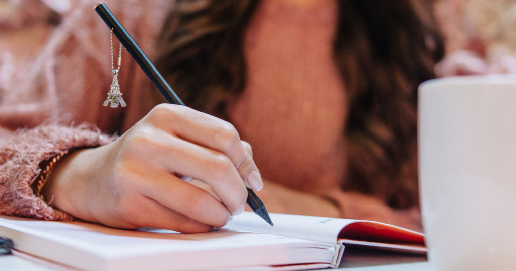 A woman writing her thoughts for creative self-expression