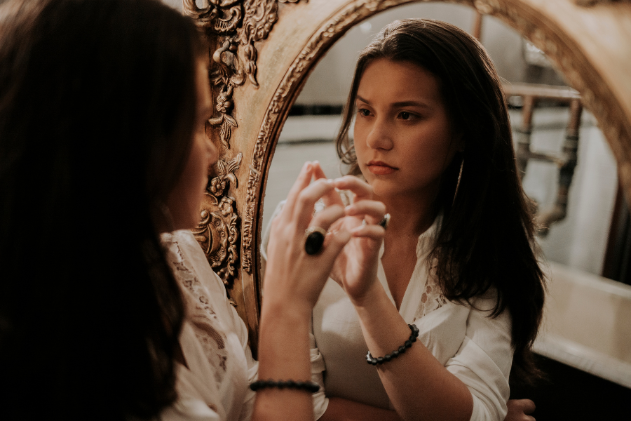 A woman looking at herself in the mirror