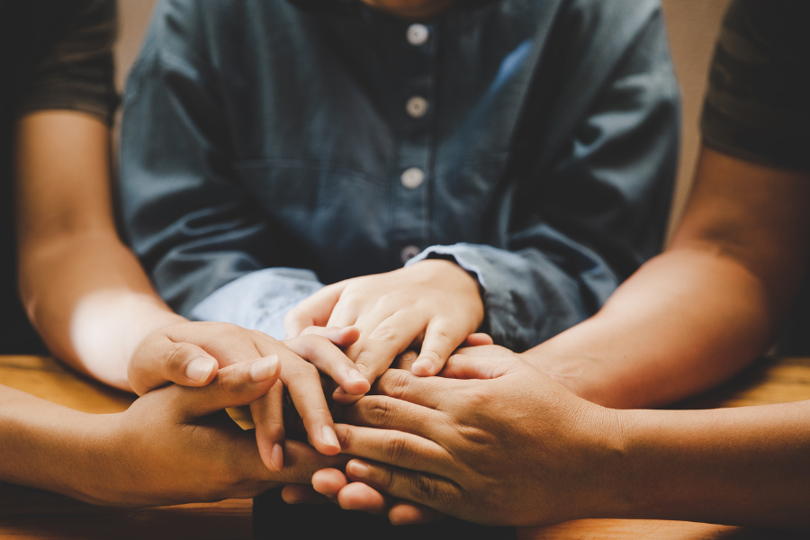 A group of friends holding each others' hands