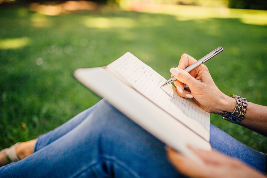 A woman writing down on her journal