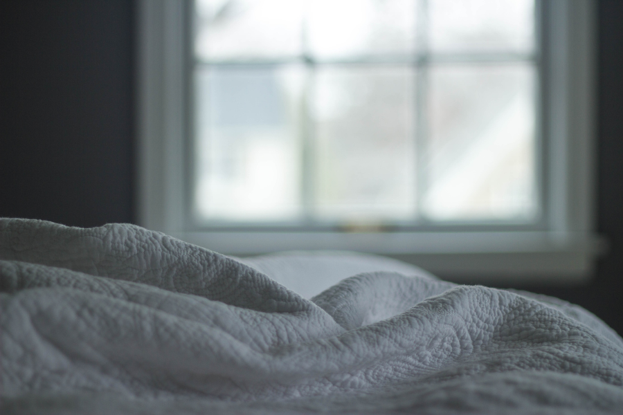 A photo of a window and bed sheets