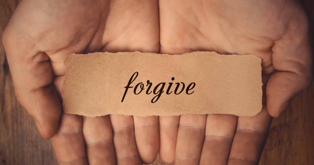 A person holding a paper with "forgive" written on it #ForgivingQuotes