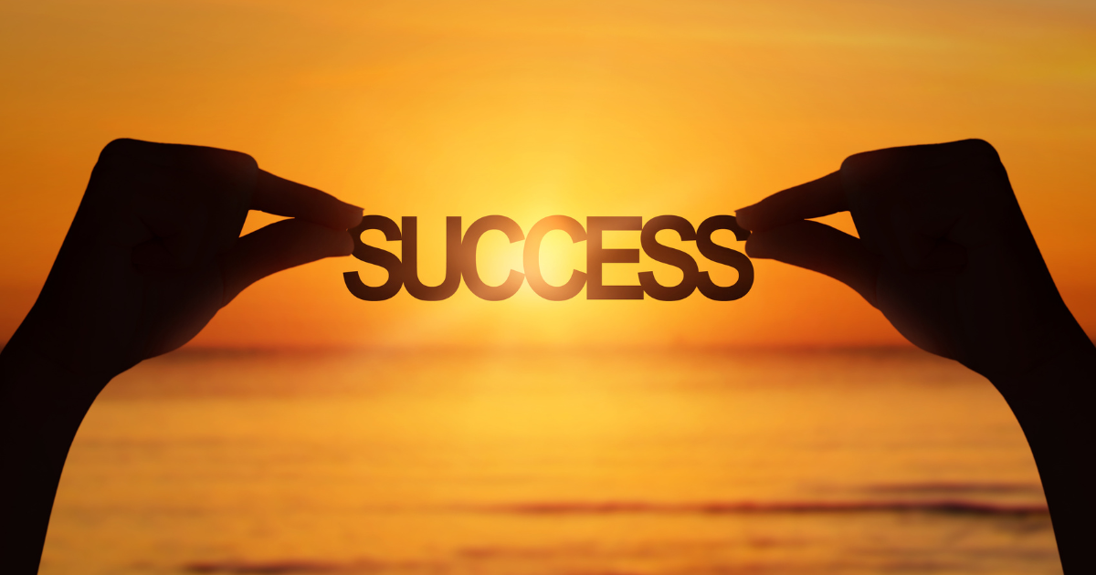 A person holding the word "success" by the beach #SuccessQuotes #AchieveDreams
