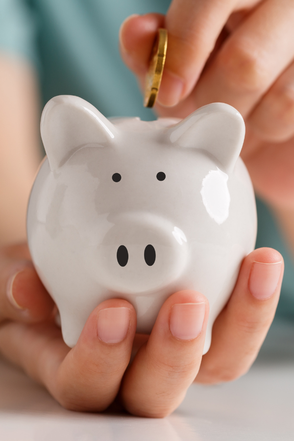 A woman putting coins in her piggy bank #FinancialPlanning #RelationshipProblems