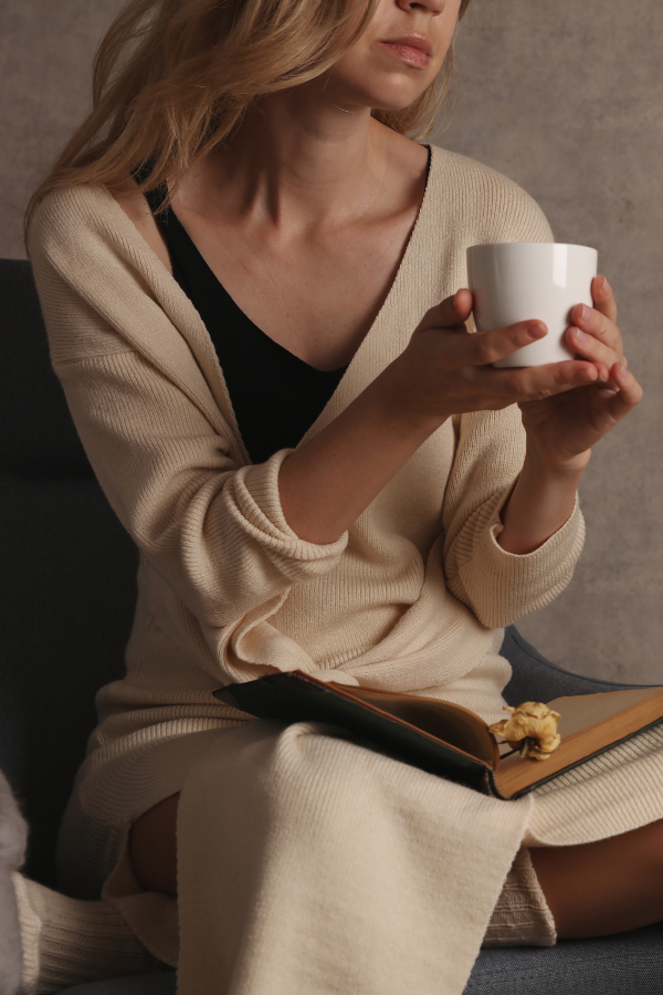 A woman feeling cozy while holding a cup of tea #LoveYourself #SelfLove