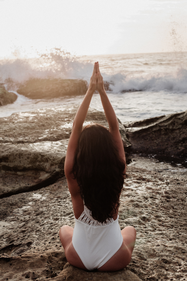 A woman doing stretches by the sea #LoveYourself #SelfLove