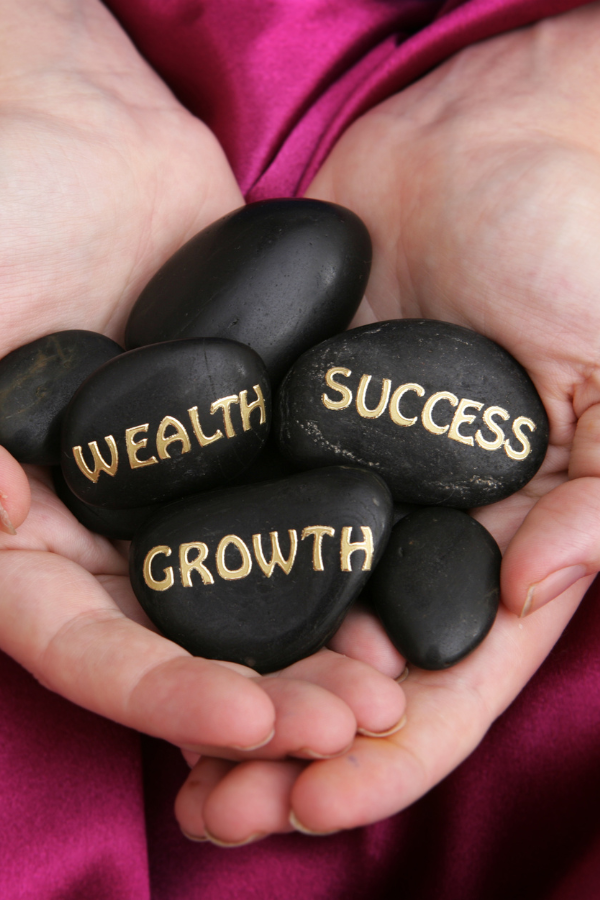 Black pebbles with the words "wealth," "success," and "growth" written on them #LoveYourself #SelfLove