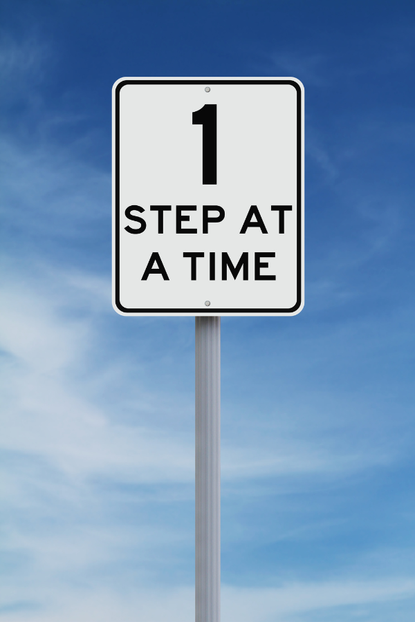 A road sign saying "1 step at a time" #OverwhlemedAtWork #WorkAnxiety