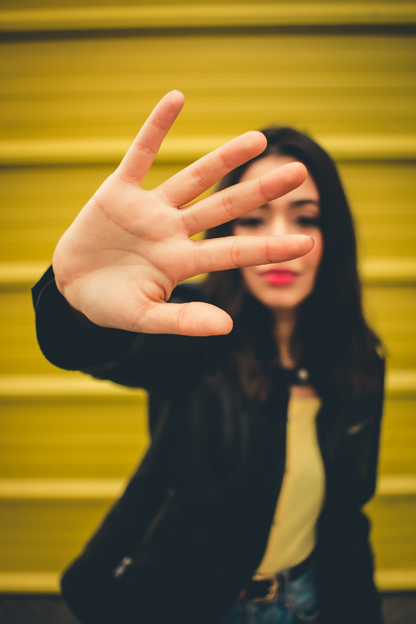 A woman holding her hand over the camera #BreakGenerationalTrauma #OvercomeTrauma