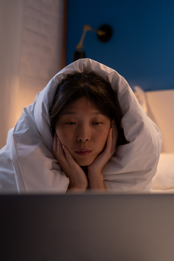 A sleepy woman looking at her laptop screen #SoloDateIdeas #BeingAlone