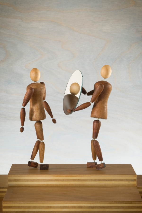 A person holding a mirror to help another person see themselves for who they are