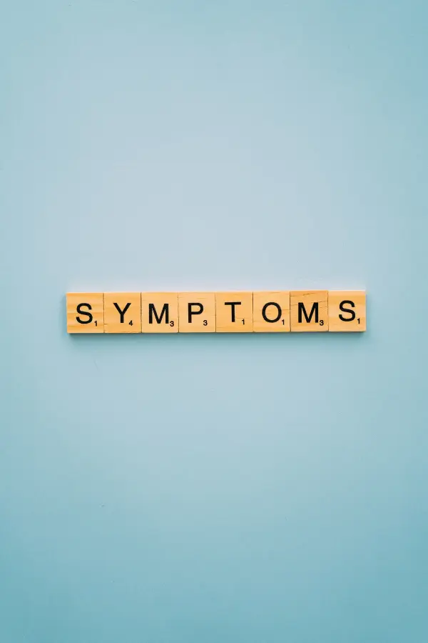 The word "symptoms" on scrabble tiles