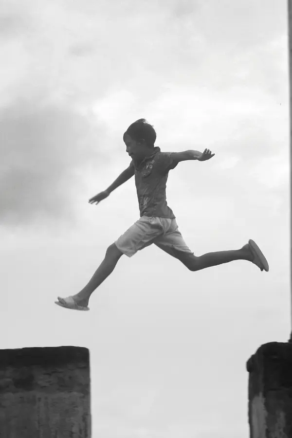 A child jumping from one pole to another